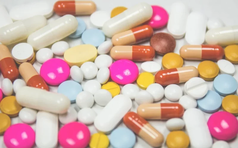 Verschieden Tabletten und Kapseln liegen durcheinander. Kapseln in beige, dunkelbraun und weiß. Tabletten in verschiedenen Größen und Formen in pink, weiß, gelb, blau, braun.