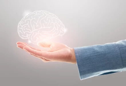 Ausgestreckte Hand über den ein holografisches Abbild eines Gehirns schwebt